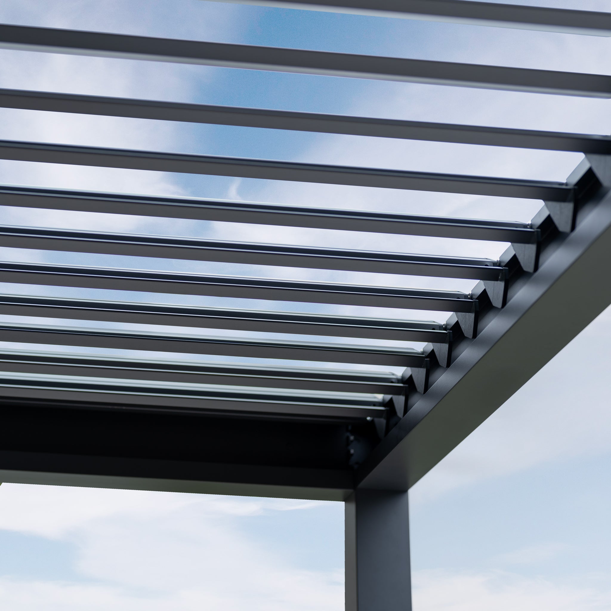 The PergoSTET Lite 2.4m x 3m Metal Rectangular Pergola in Grey features a sleek roof with horizontal slats and modern tilting louvres, providing stylish outdoor shade under a blue sky with light clouds, as seen from below.