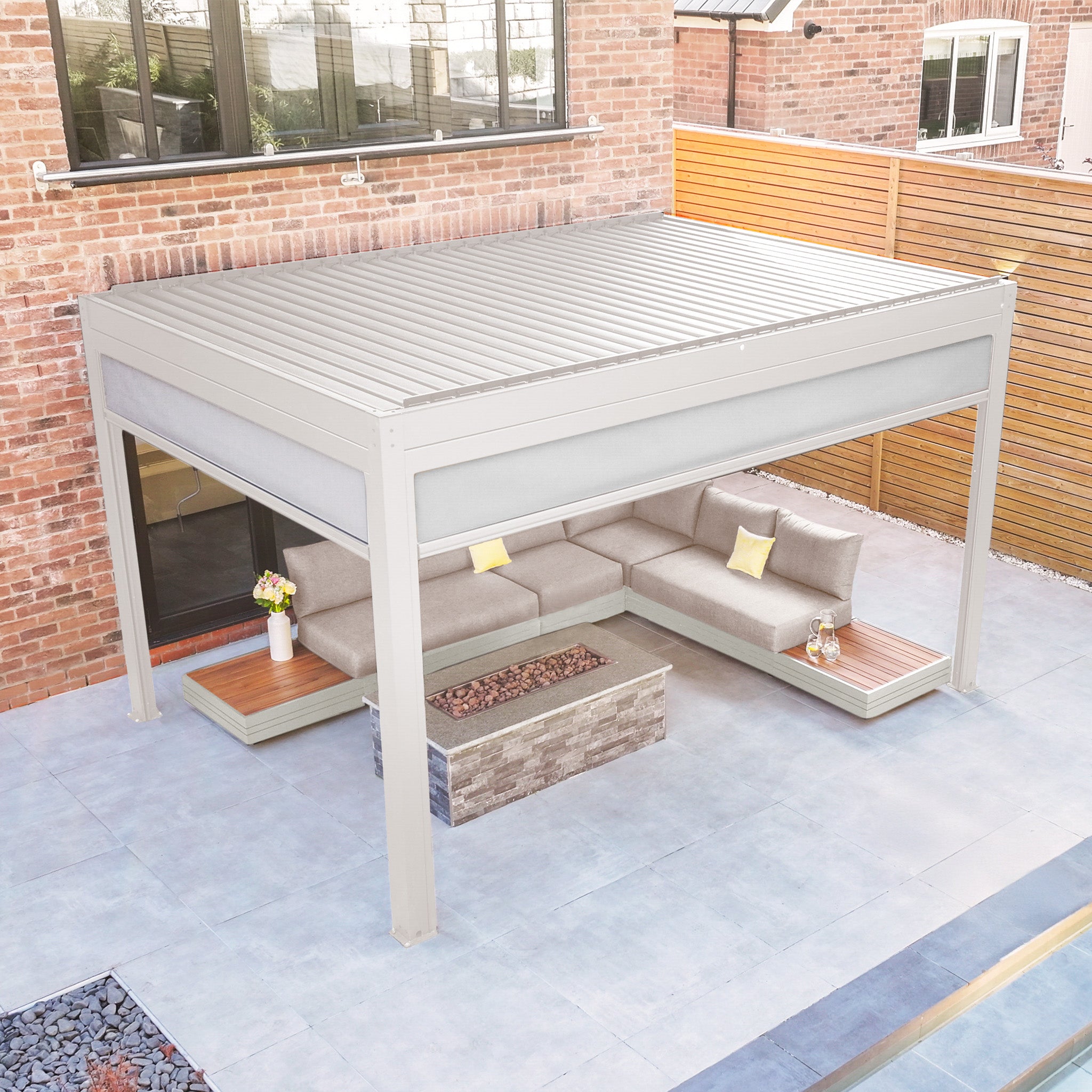 Modern outdoor patio with the PergoSTET Plus 3m x 4m Rectangular Pergola in Latte, featuring a waterproof roof, built-in drainage, 3 drop sides, and LED lighting, complemented by a sectional sofa, coffee table, and plants on tiled flooring.