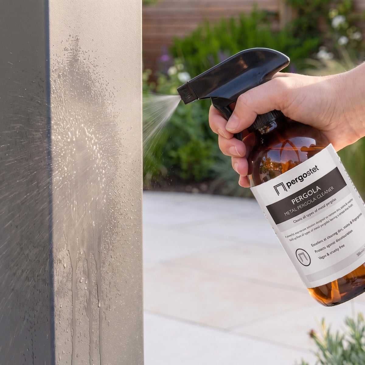 Spraying Outdoor Aluminium and Steel Pergola Cleaner onto a grey metal pergola post outdoors.