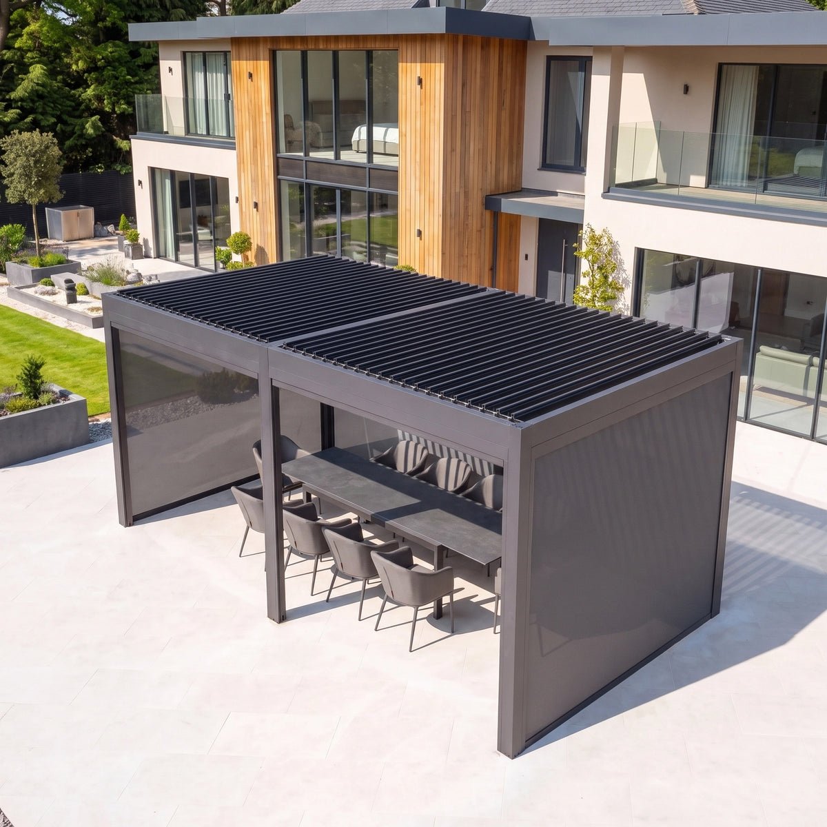 PergoSTET Deluxe 3m x 6m Rectangular Pergola with motorised louvred roof, side blinds, and patio dining set.