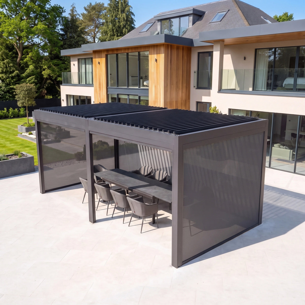 PergoSTET Deluxe 3m x 6m Rectangular Pergola with motorised grey louvres and integrated LED lighting over patio furniture.