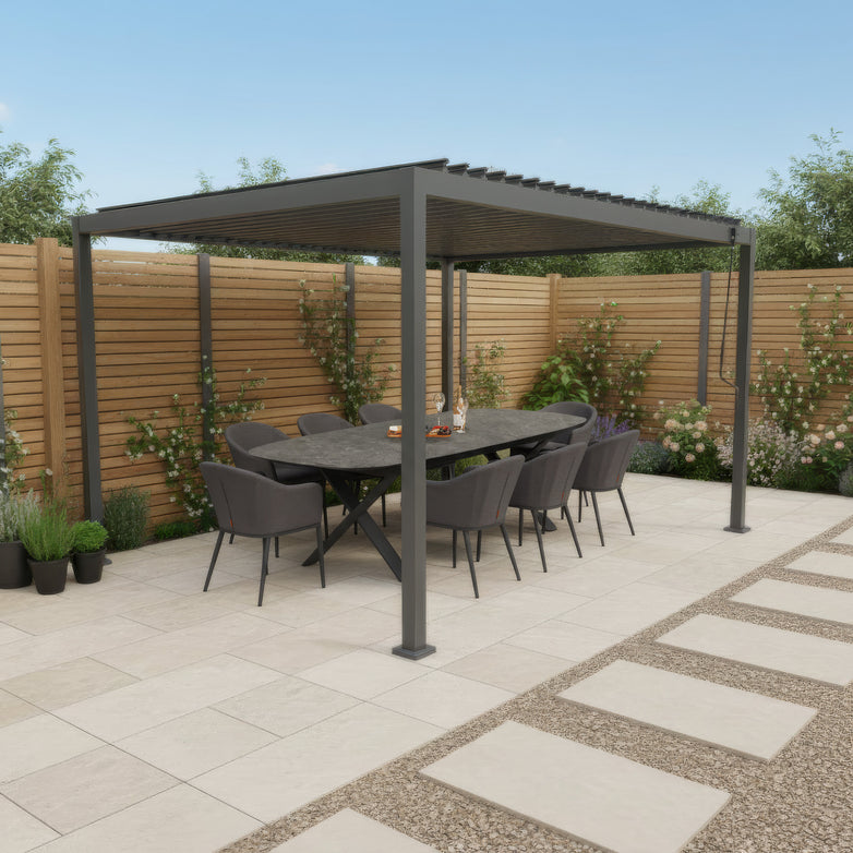 The PergoSTET Lite 3m x 4m Metal Rectangular Pergola in Grey shelters a modern outdoor dining set with six chairs on a tiled patio, featuring tilting louvres and surrounded by plants and fencing.