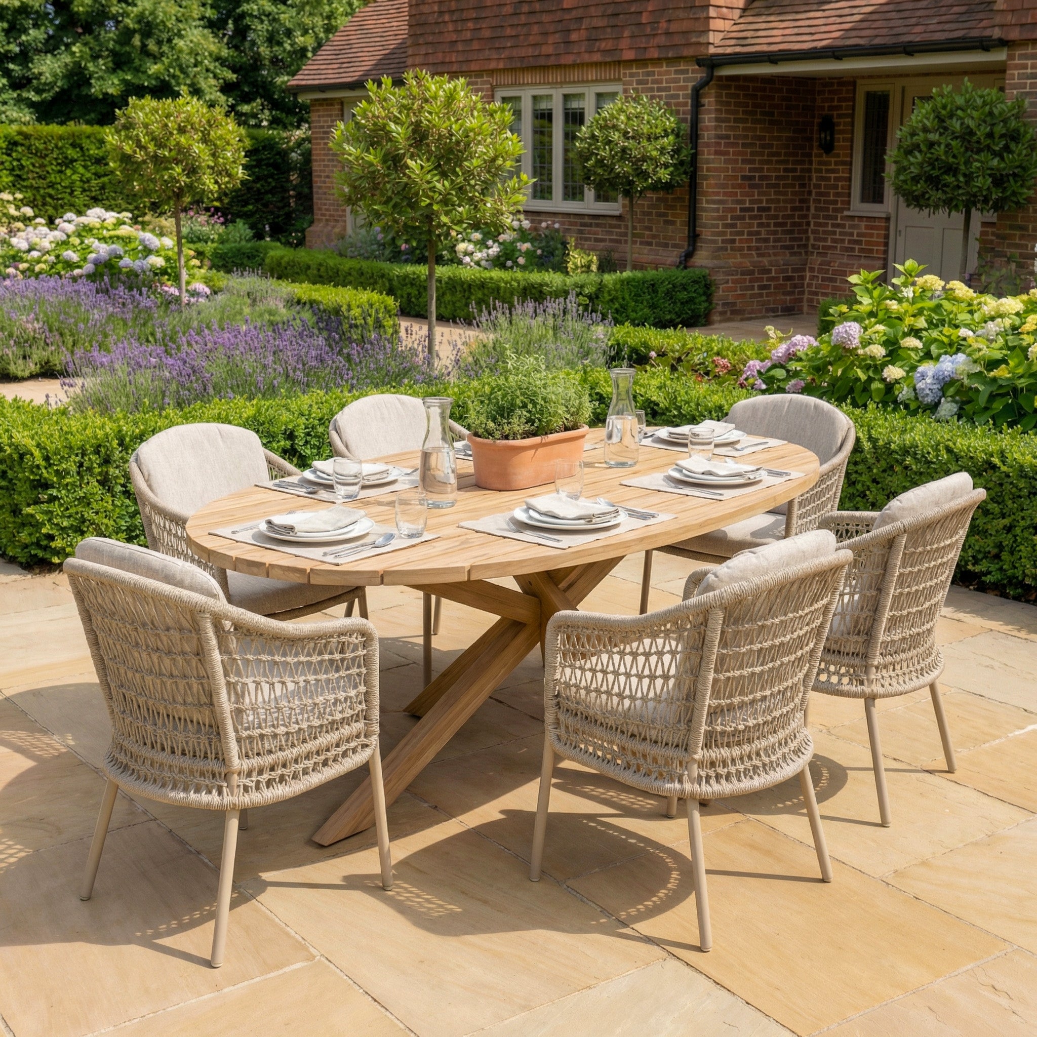 The Puccini 6 Seat Oval Dining Set in Latte is set up in a sunny garden patio, offering an inviting and stylish outdoor dining space.