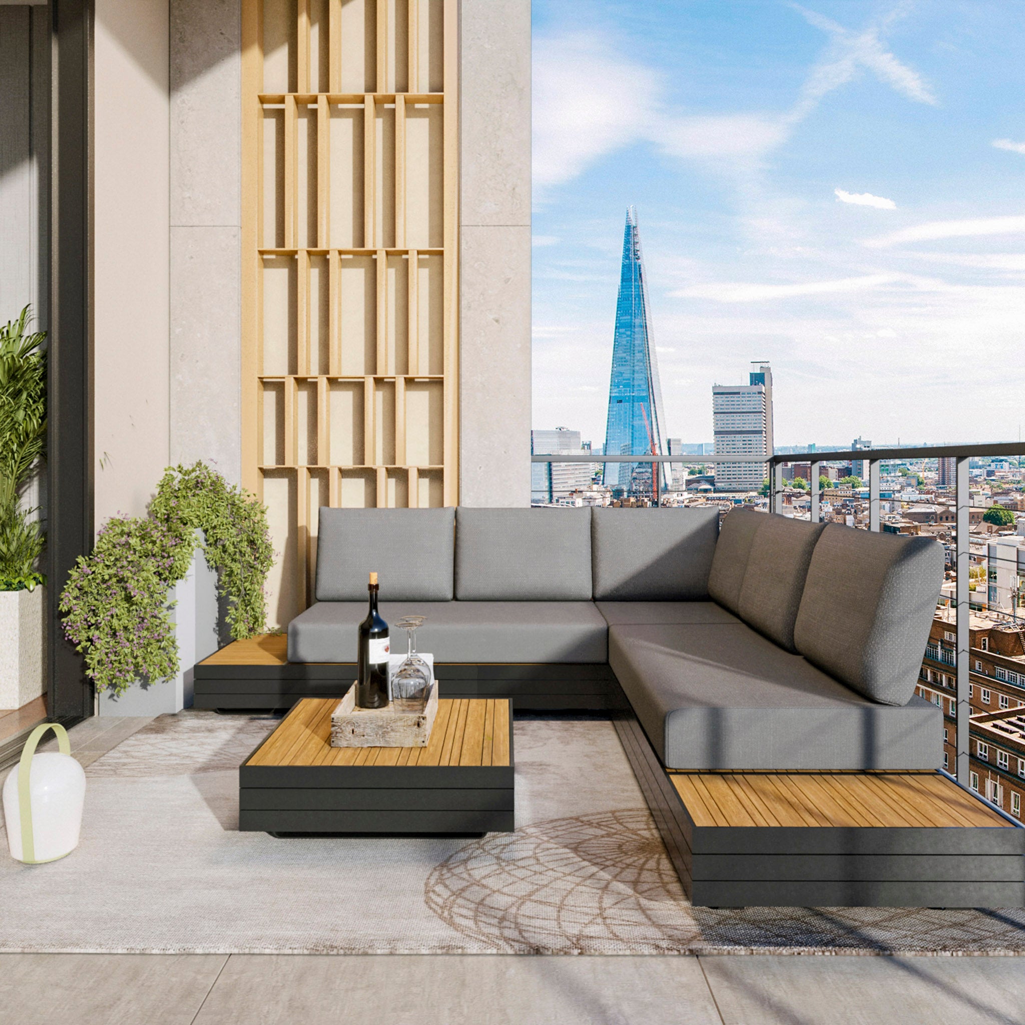 Modern rooftop patio featuring the Panama Luxury Outdoor Corner Group Set in Washed Grey, a sustainable teak coffee table, and a view of the cityscape including a tall iconic building.