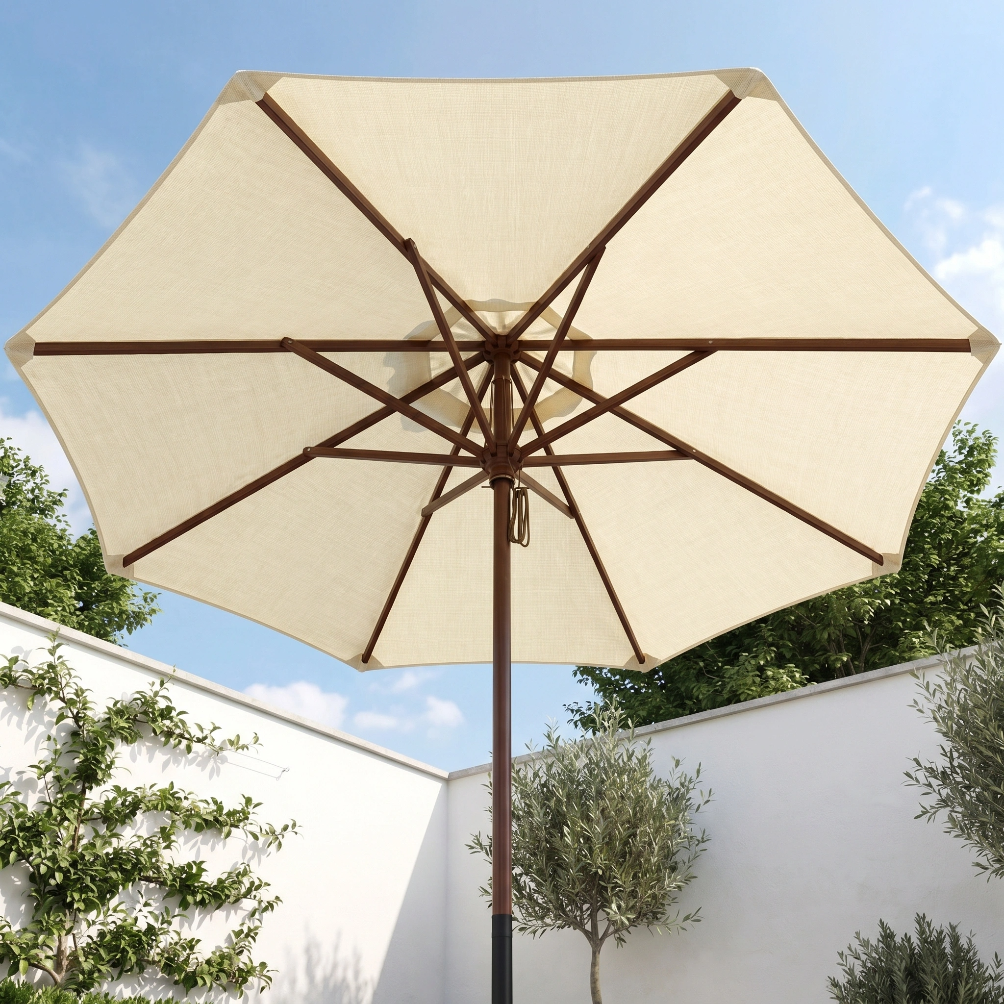 The Styx 3m Round Deluxe Wooden Parasol in Beige stands in a sunny walled garden filled with green plants.