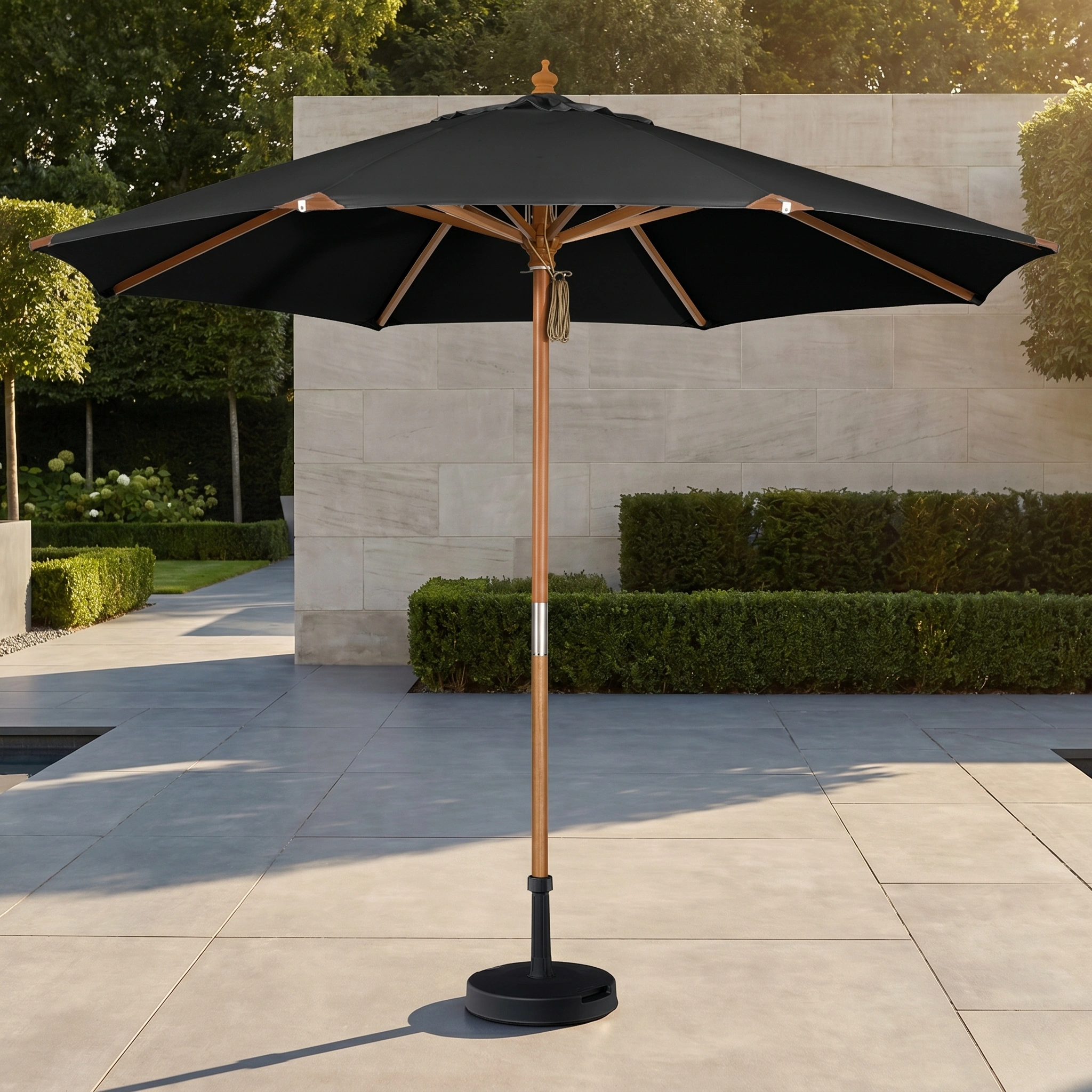 The Styx 3m Round Deluxe Wooden Parasol in Black stands on a tiled patio near trimmed hedges, providing stylish UV protection.