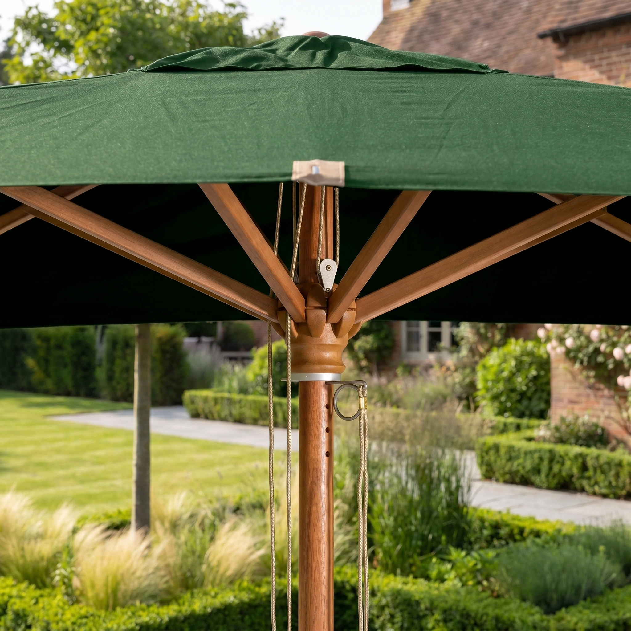 Close-up of the Styx 3m x 2m Rectangular Deluxe Wooden Parasol in Green, standing in a landscaped garden.
