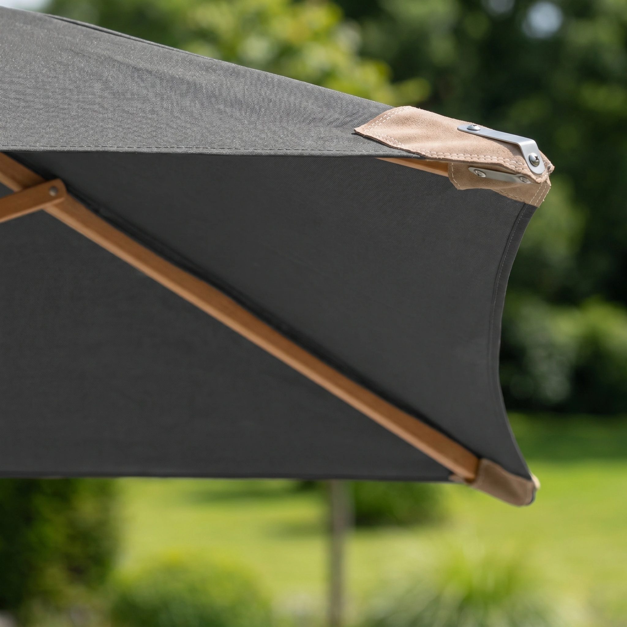 Close-up of a grey Styx 3m x 2m Rectangular Deluxe Wooden Parasol with a sturdy wooden frame, set outdoors in a lush green garden.