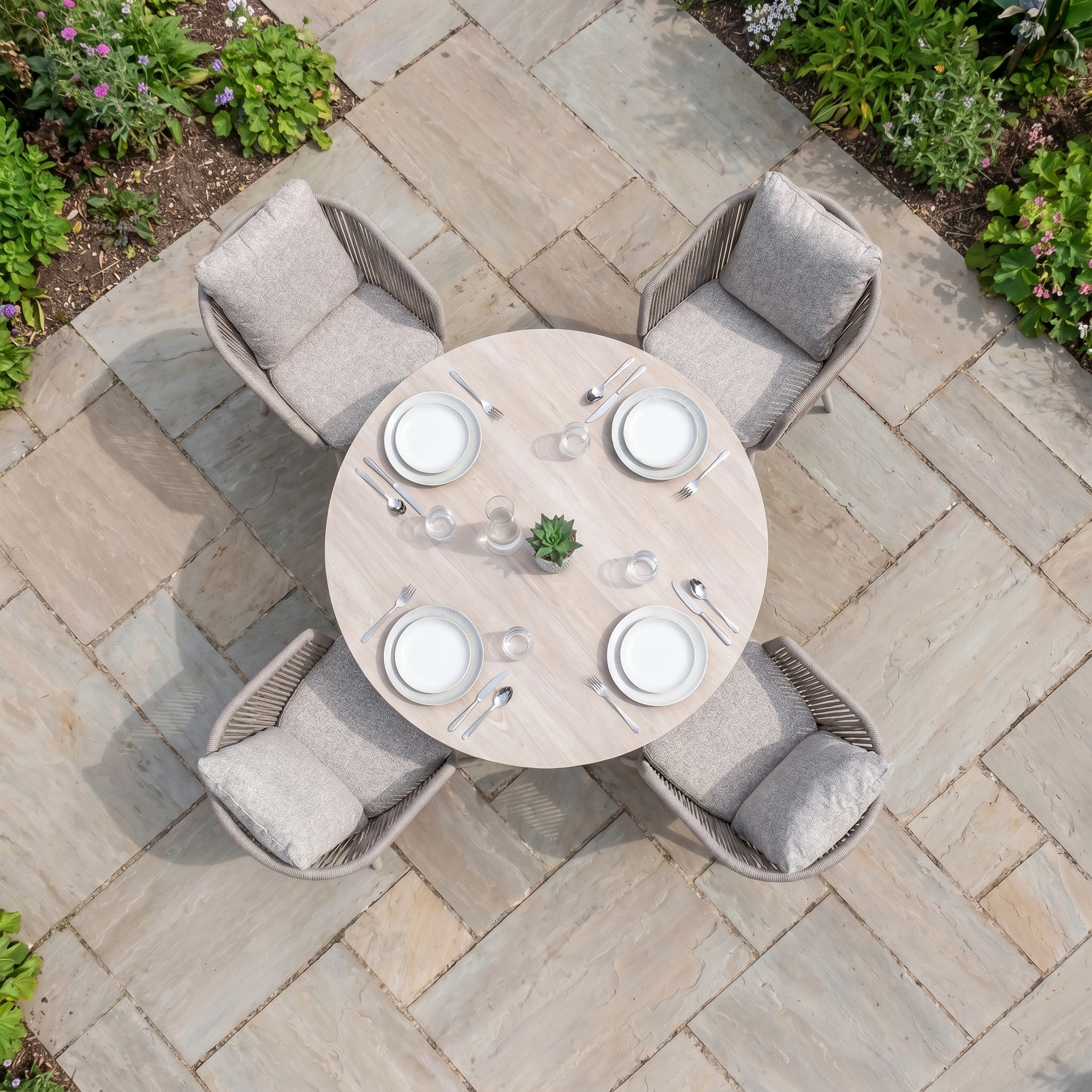 Enjoy stylish alfresco meals with the Theia 4 Seat Round Rope Dining Set with Albatross Table in Oatmeal, complete with cushioned chairs and dining essentials, ideal for a stone patio gathering.