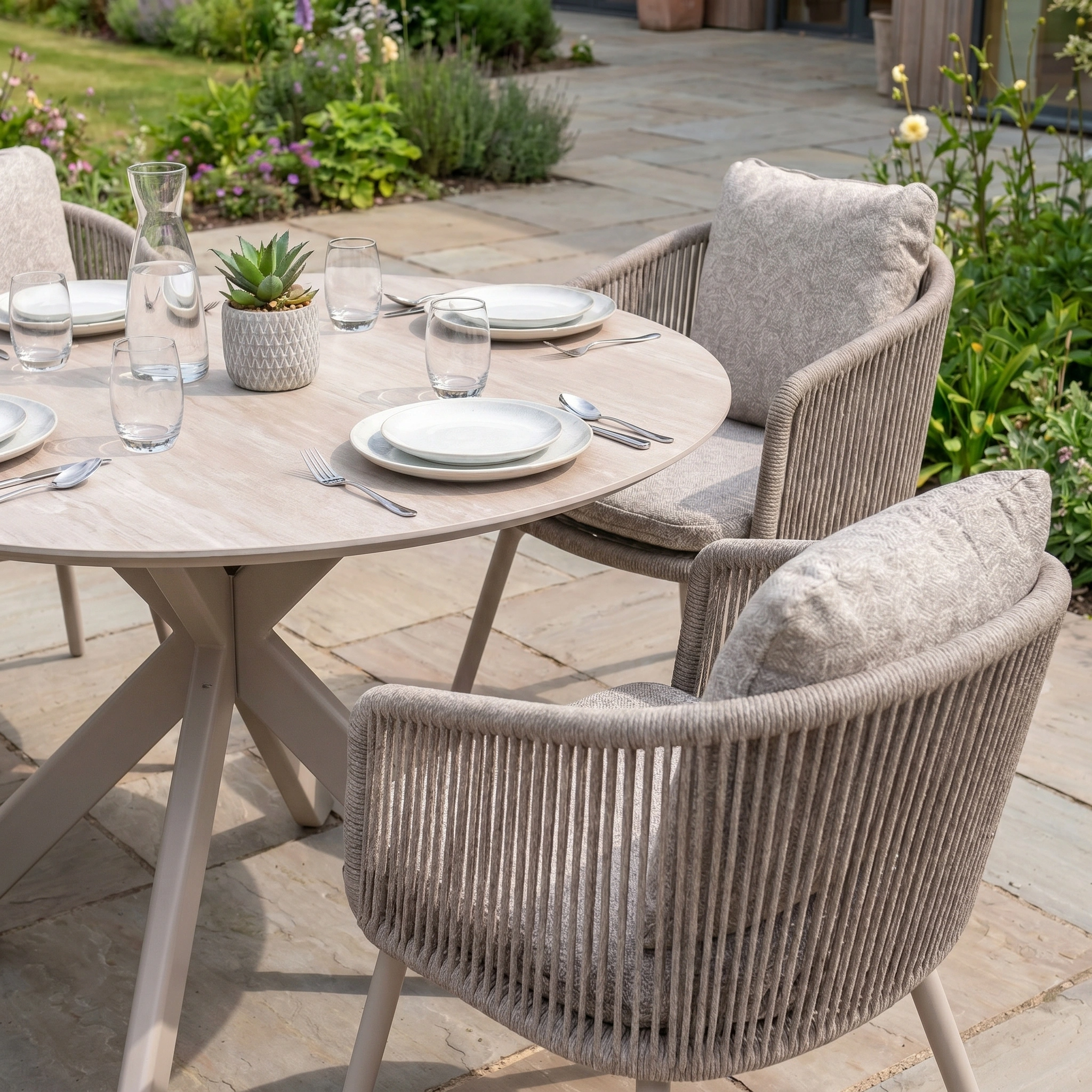 The Theia 4 Seat Round Rope Dining Set with Albatross Table in Oatmeal brings effortless elegance to your patio, ideal for relaxing outdoor meals with rope chairs and a light wood table. Perfect as stylish garden furniture.