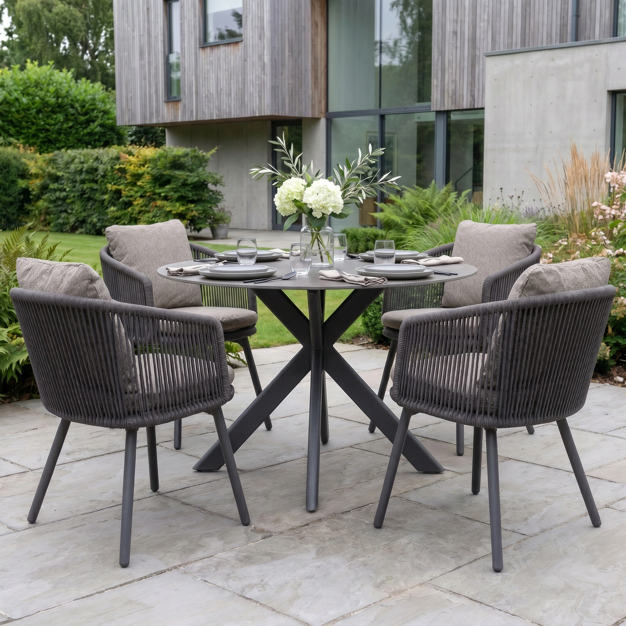 Theia 4 Seat Round Rope Dining Set with Albatross Table in Truffle adds modern elegance to your patio with its stylish grey woven chairs and durable aluminium garden furniture.