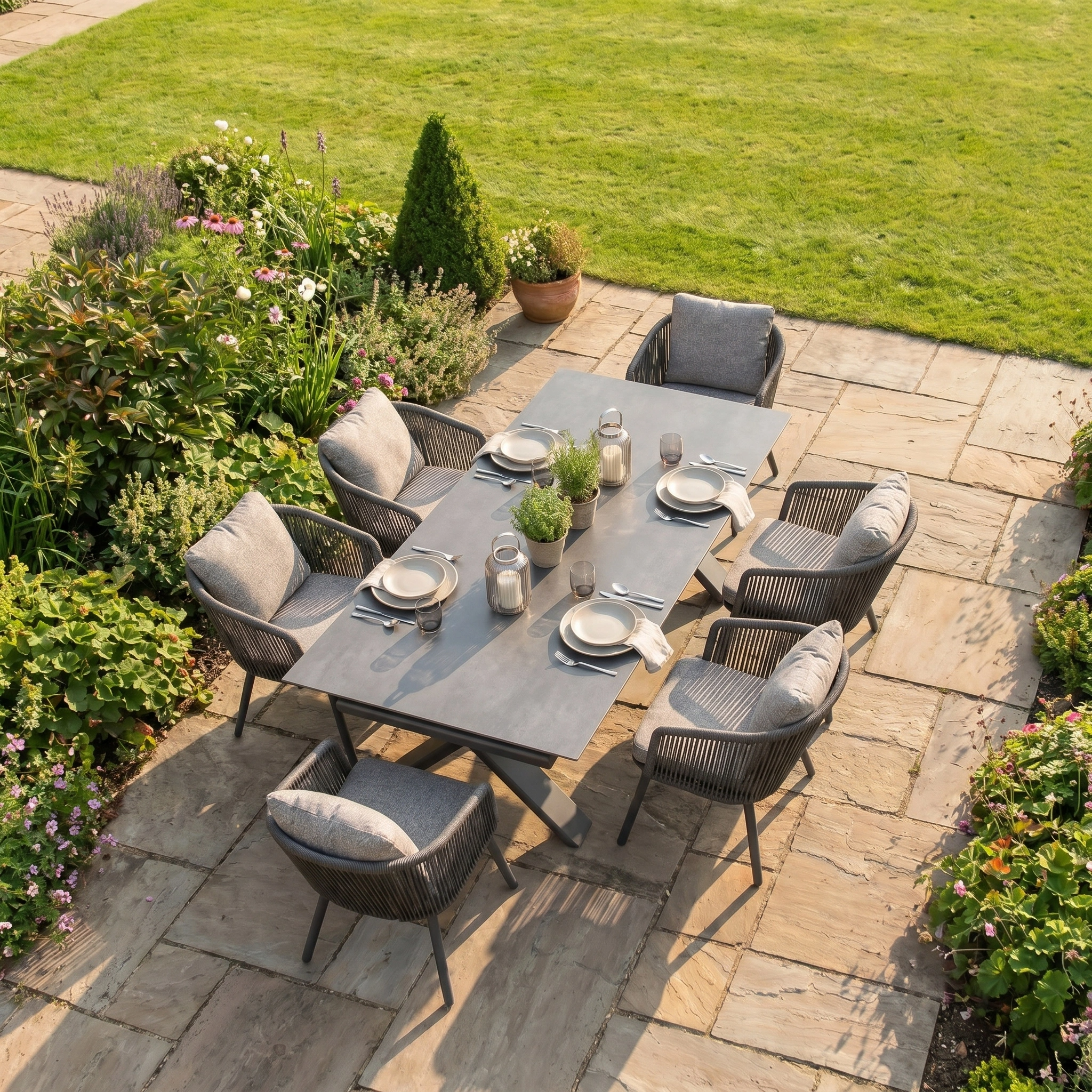 The Theia 6 Seat Rope Dining Set with Albatross Extending Table in Truffle offers stylish garden dining, featuring an extending table and six chairs—ideal outdoor furniture for enjoying al fresco meals surrounded by greenery.