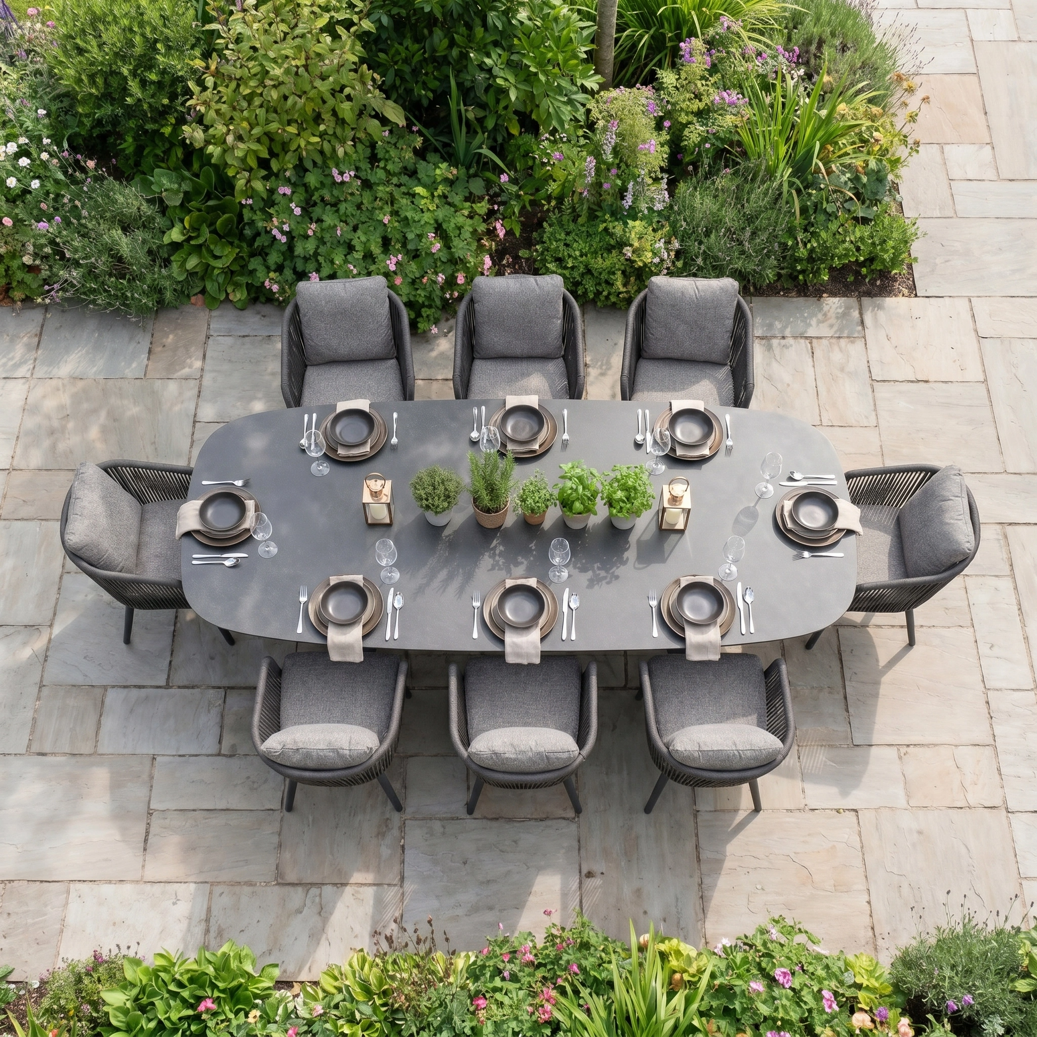 Theia 8 Seat Oval Rope Dining Set with Albatross Extending Table in Truffle includes elegant chairs and is perfect for stylish outdoor dining amidst greenery.