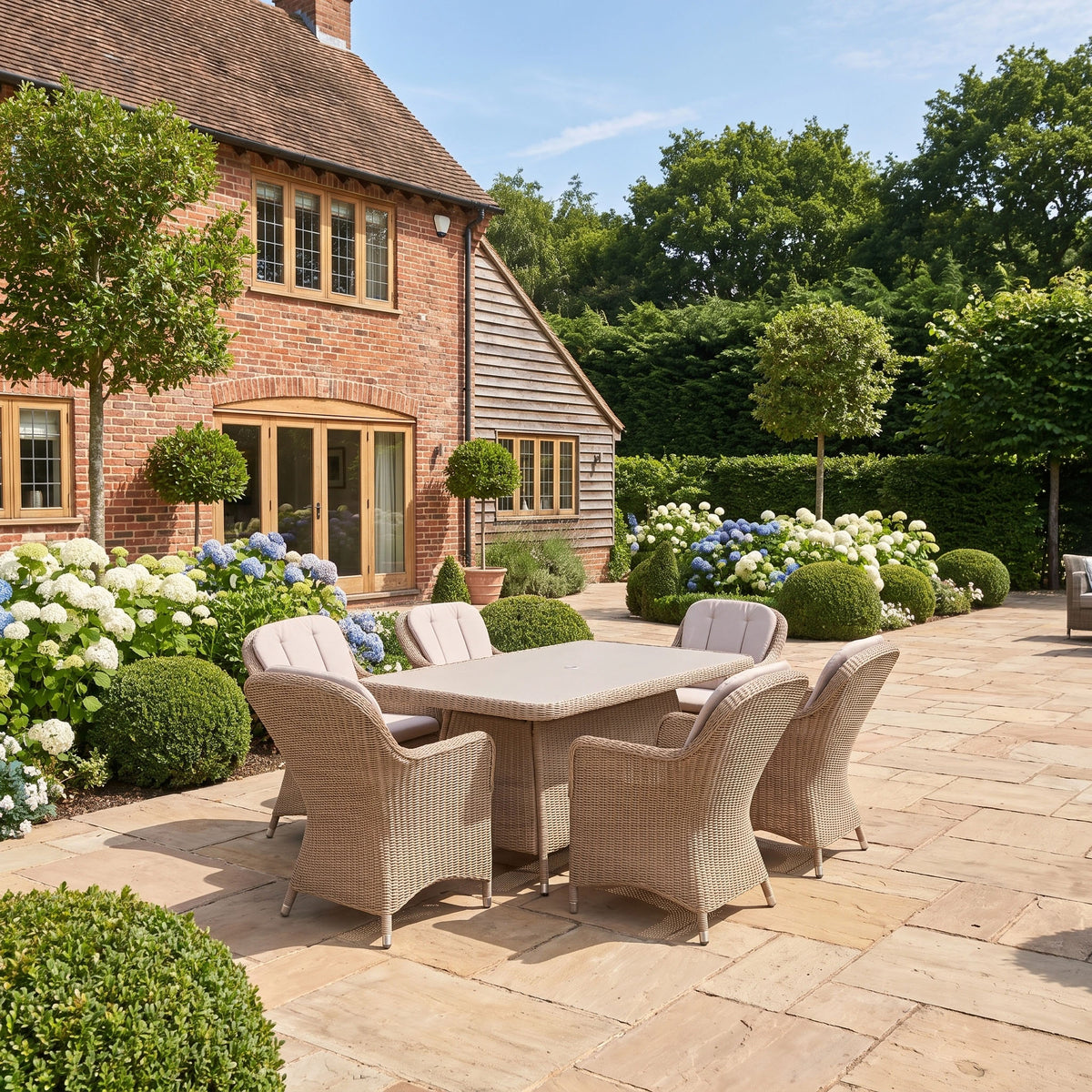 a patio with a table and chairs in front of a brick house