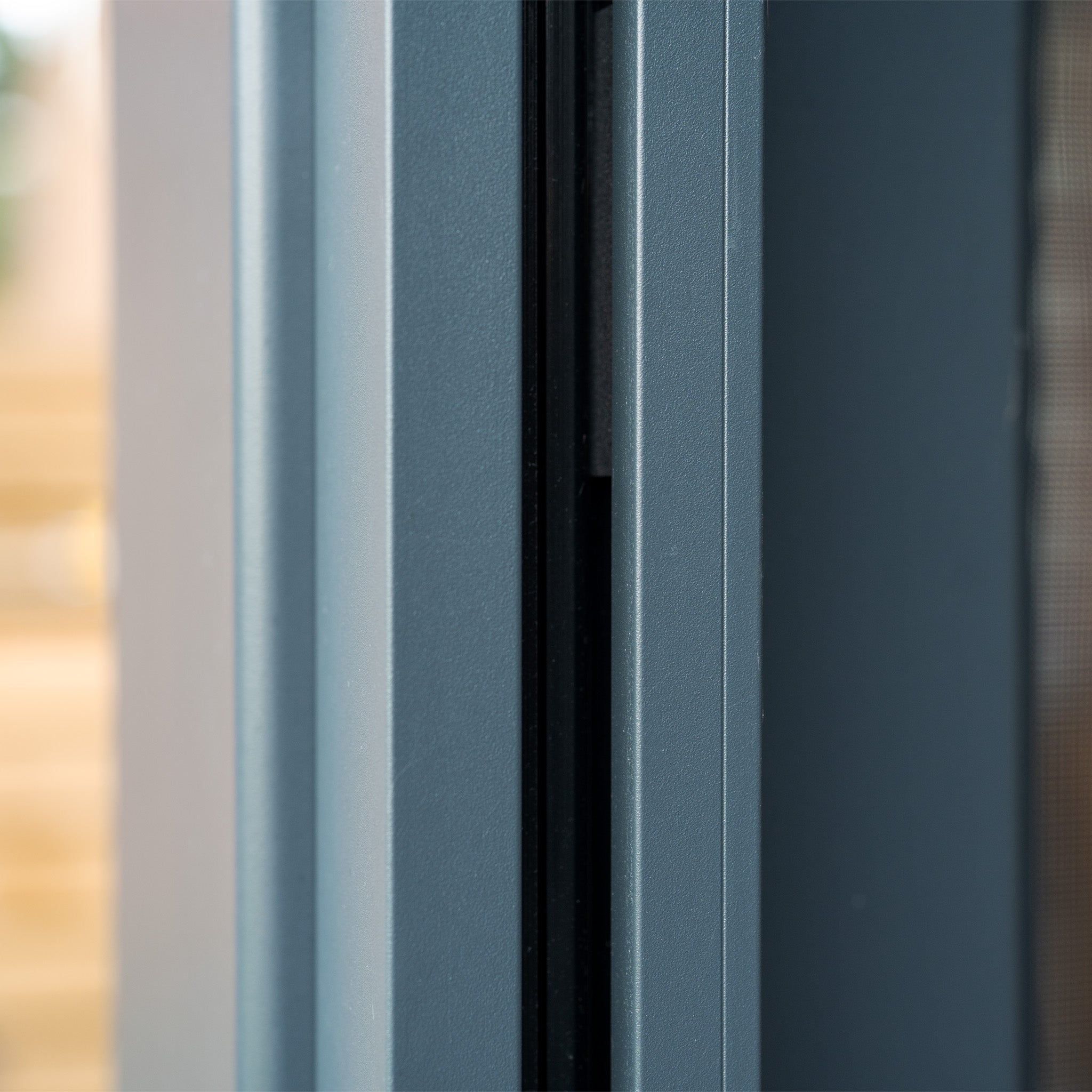 Close-up of a modern, grey window frame, showcasing a sleek, minimalist design that perfectly complements the PergoSTET Plus 3m x 4m rectangular wall mounted pergola with 3 drop sides and LED lighting in grey.
