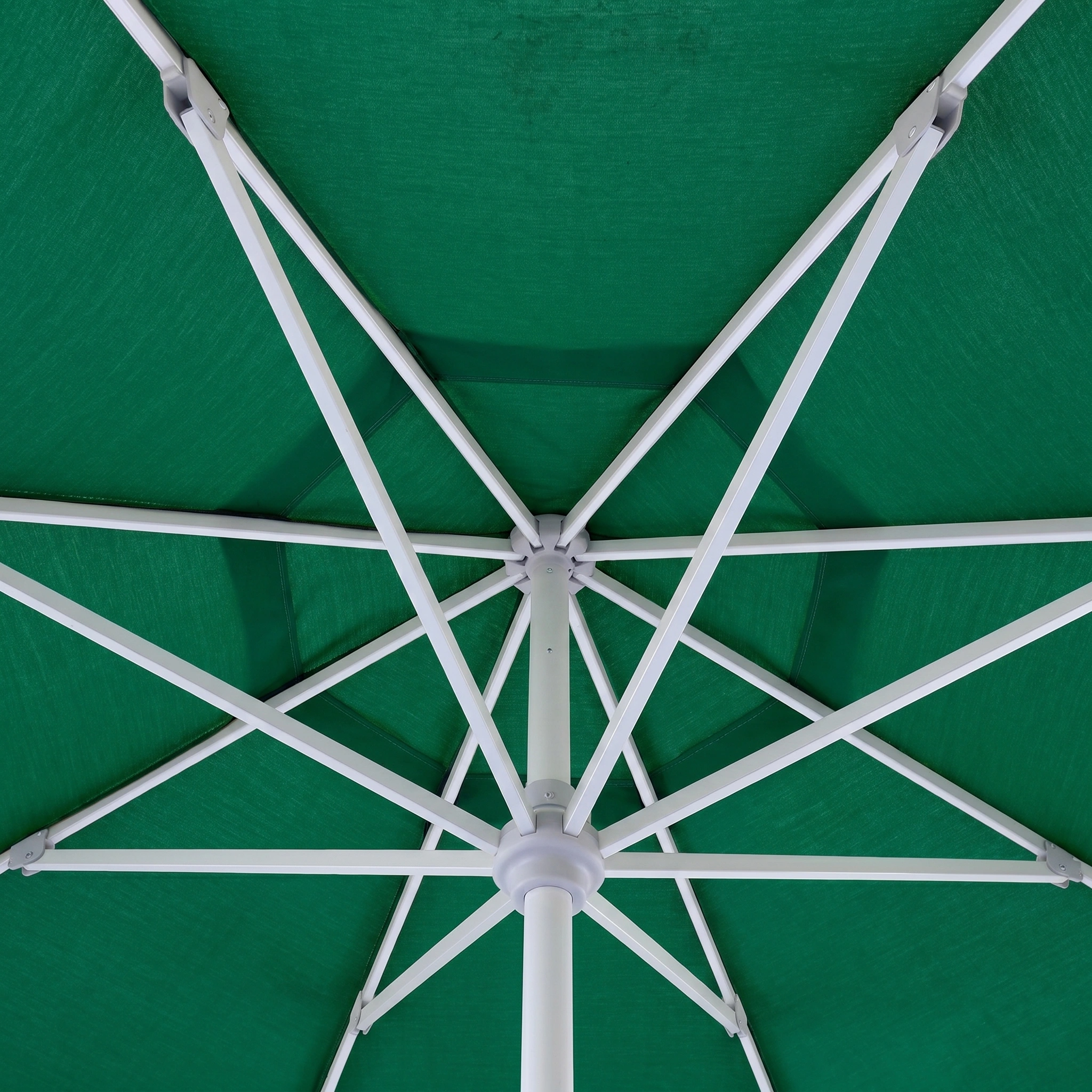 A view from beneath the Zelos 2.5M Round Parasol with LED Lighting in Green showcases its white metal spokes and central support structure.