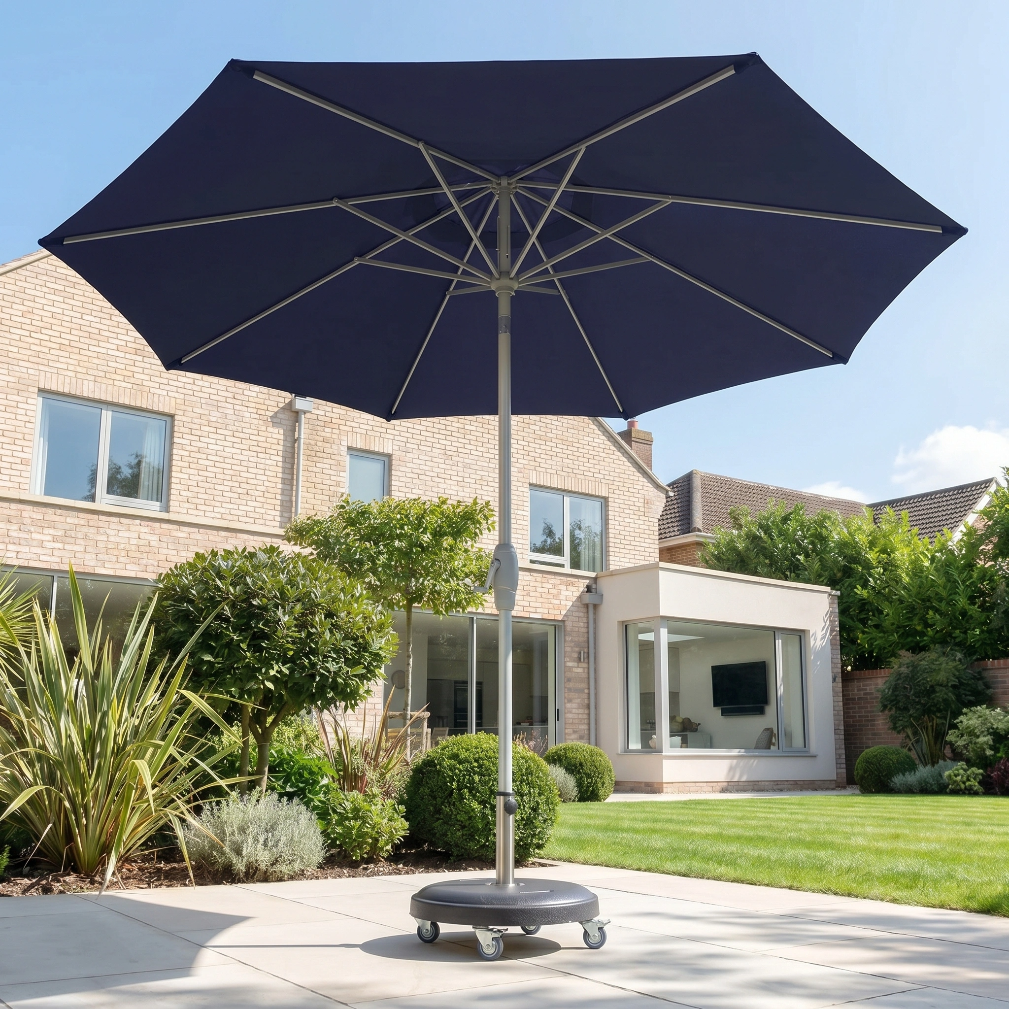 The Zelos 3m Round Parasol with LED Lighting in Navy stands on a sunny tiled terrace in a modern garden.