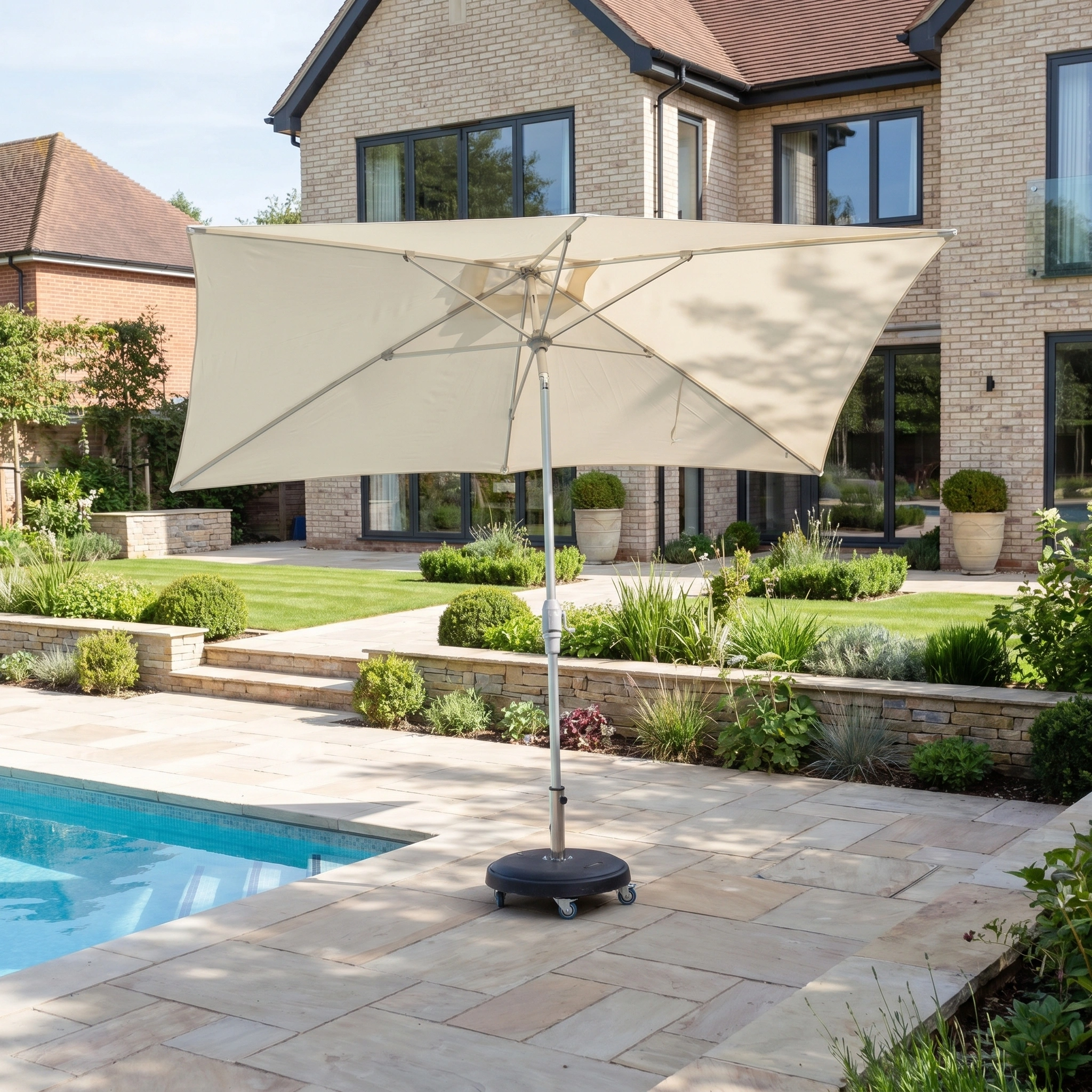 The Zelos 3m x 2m Rectangular Parasol with LED Lighting in Cream stands by a pool in a landscaped backyard near a modern house, providing stylish UV protection for outdoor spaces.