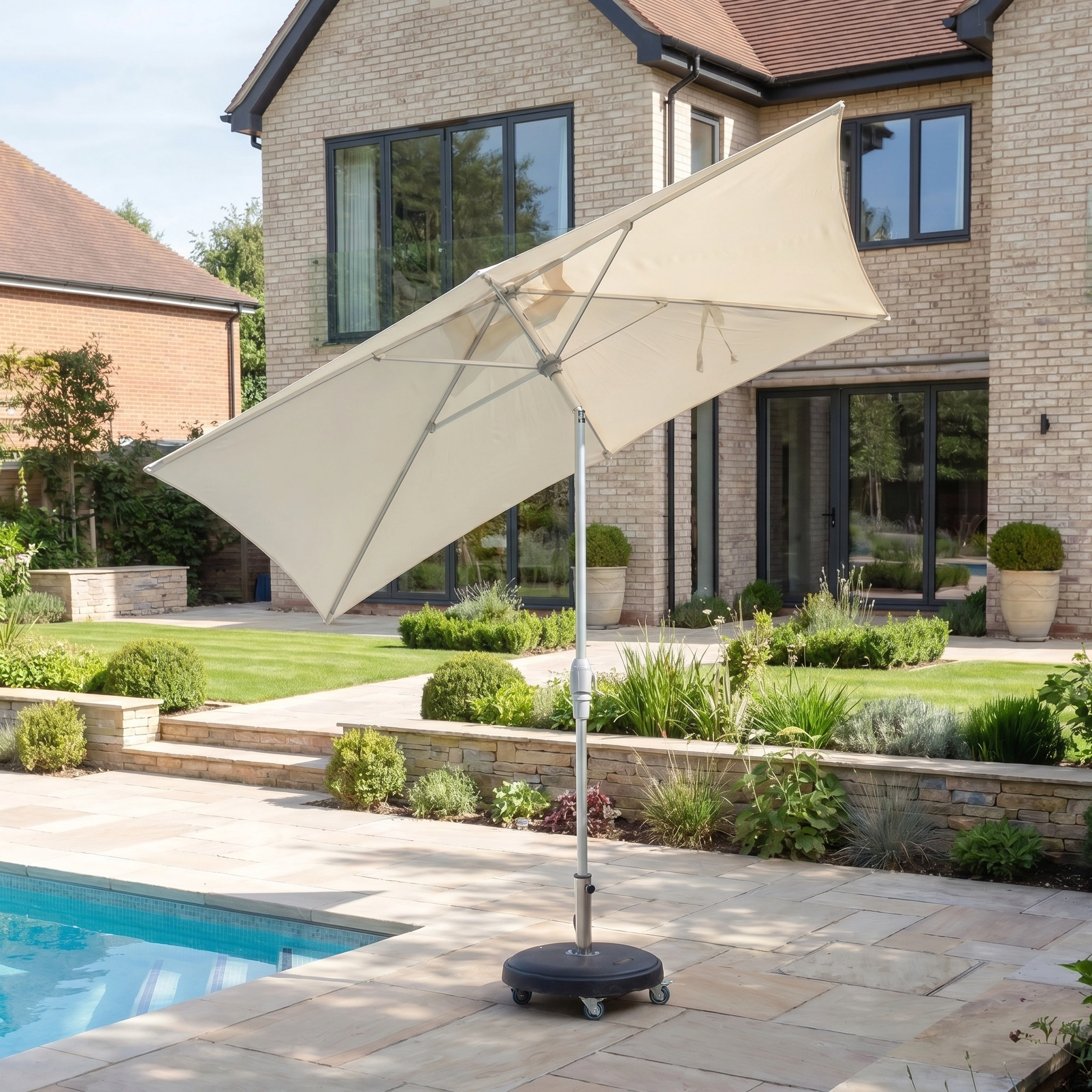 The Zelos 3m x 2m Rectangular Parasol with LED Lighting in Cream provides stylish UV protection for your modern backyard or poolside area, perfectly complementing a brick house while adding a contemporary touch.