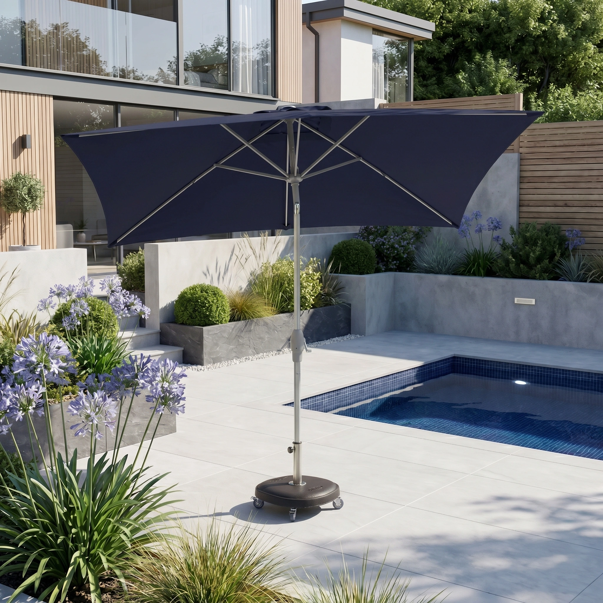 Modern backyard patio with a Zelos 3m x 2m Rectangular Parasol with LED Lighting in Navy beside a small swimming pool and landscaped plants.
