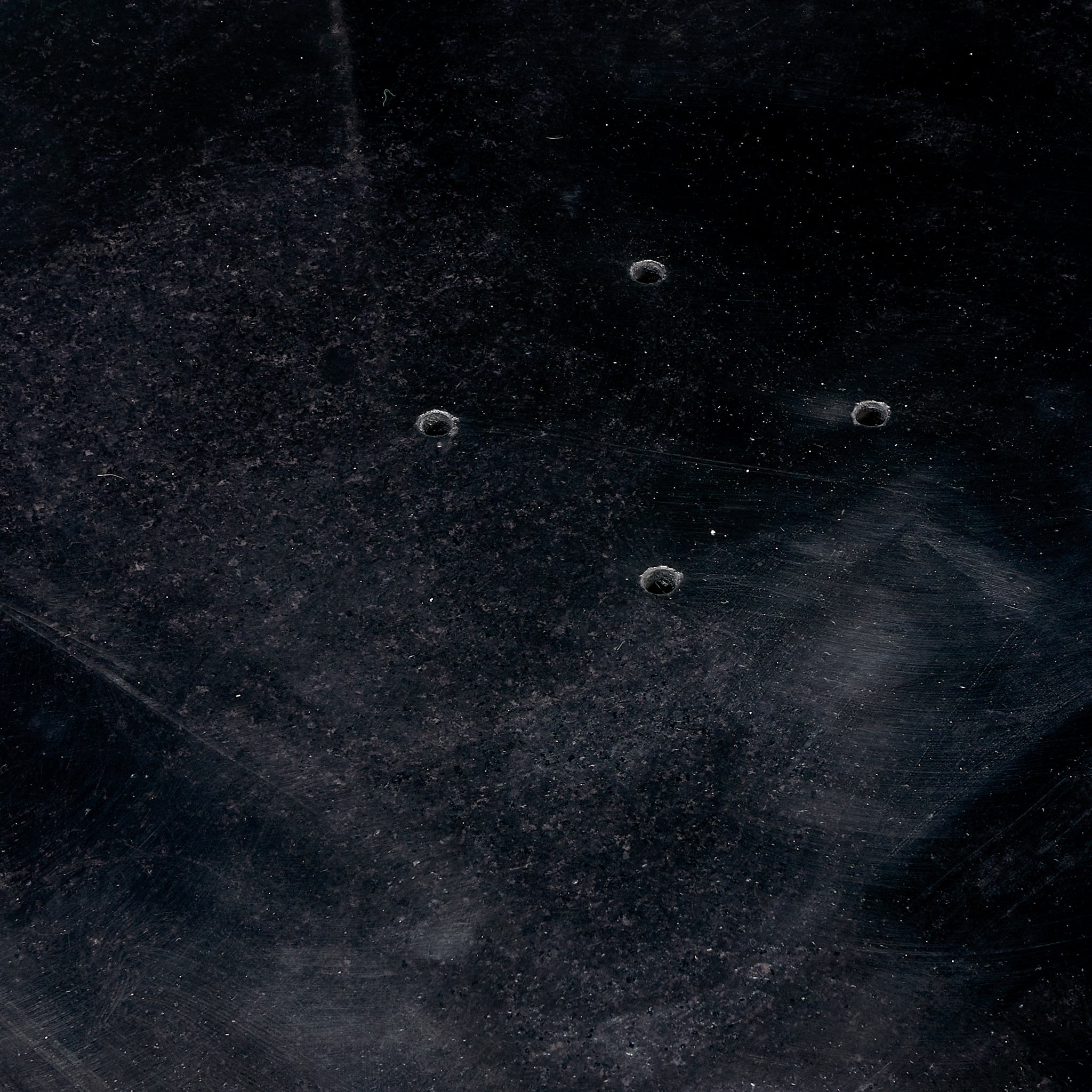 The Pacific Lifestyle Modena Parasol Base is crafted from polished black granite, reminiscent of textured granite with four small circular indents near the center.