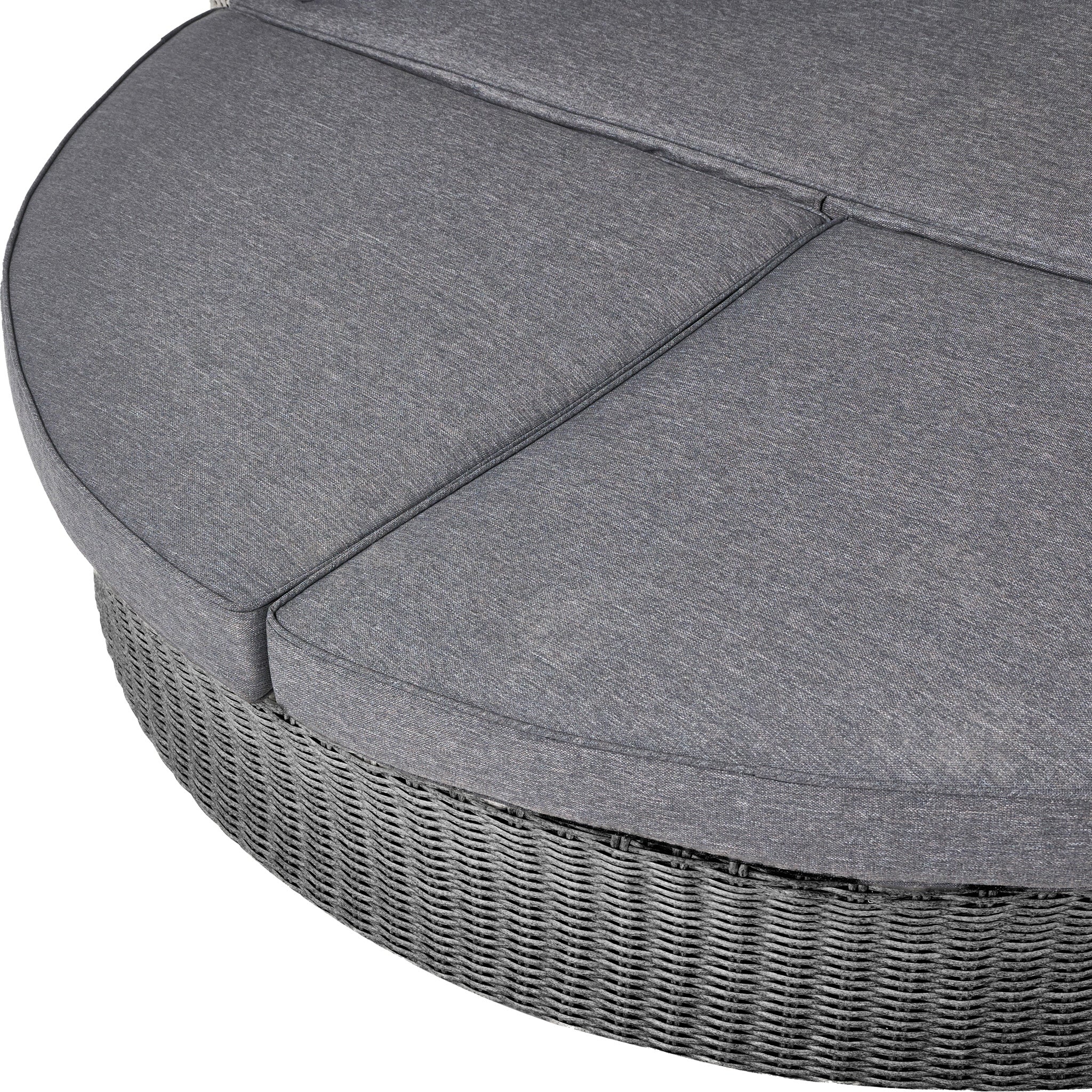 The Pacific Lifestyle Bermuda Daybed in Slate Grey is a round, space-saving outdoor wicker ottoman with a weatherproof design and a cushioned top divided into three sections.