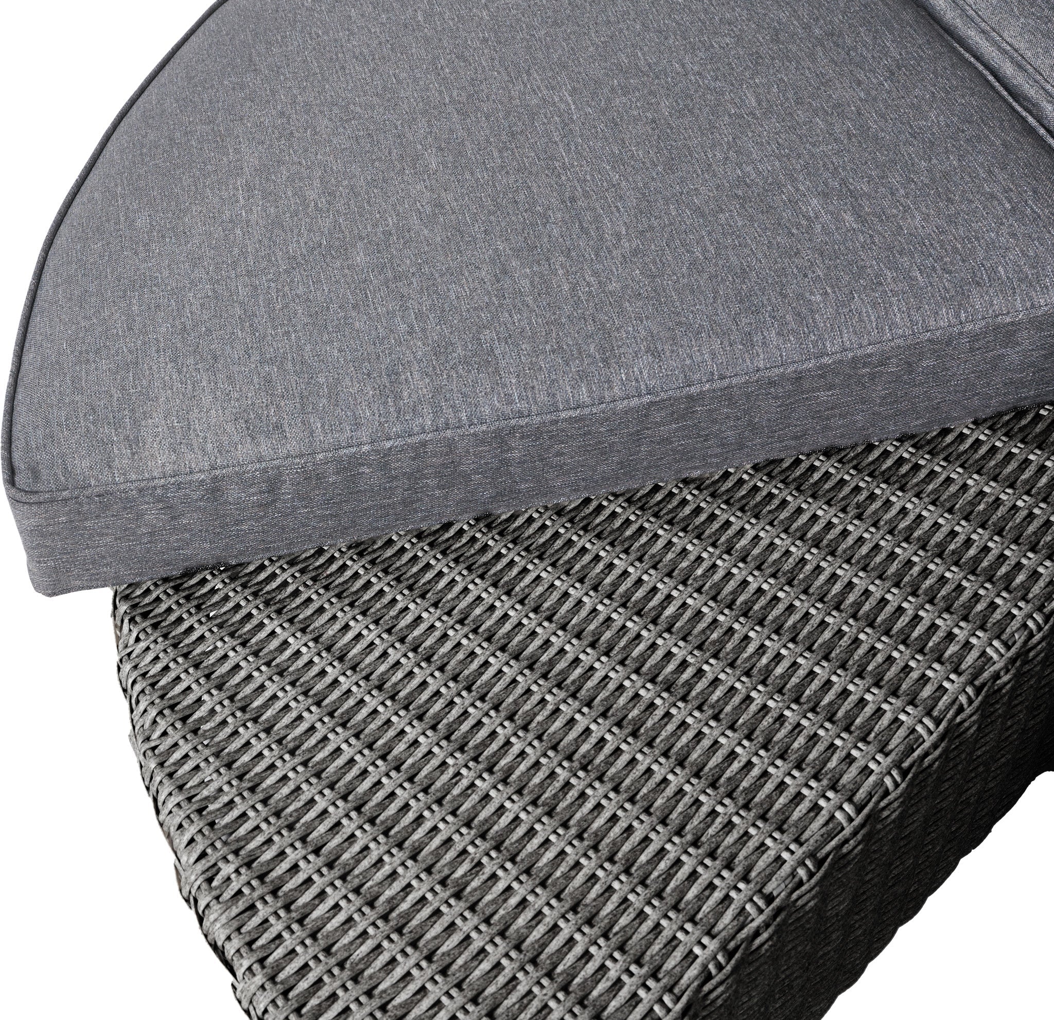 A grey triangular cushion sits elegantly on a woven wicker patio chair, highlighting its weatherproof charm. Viewed from an angle, it complements the space-saving design of the Pacific Lifestyle - Bermuda Daybed in Slate Grey.