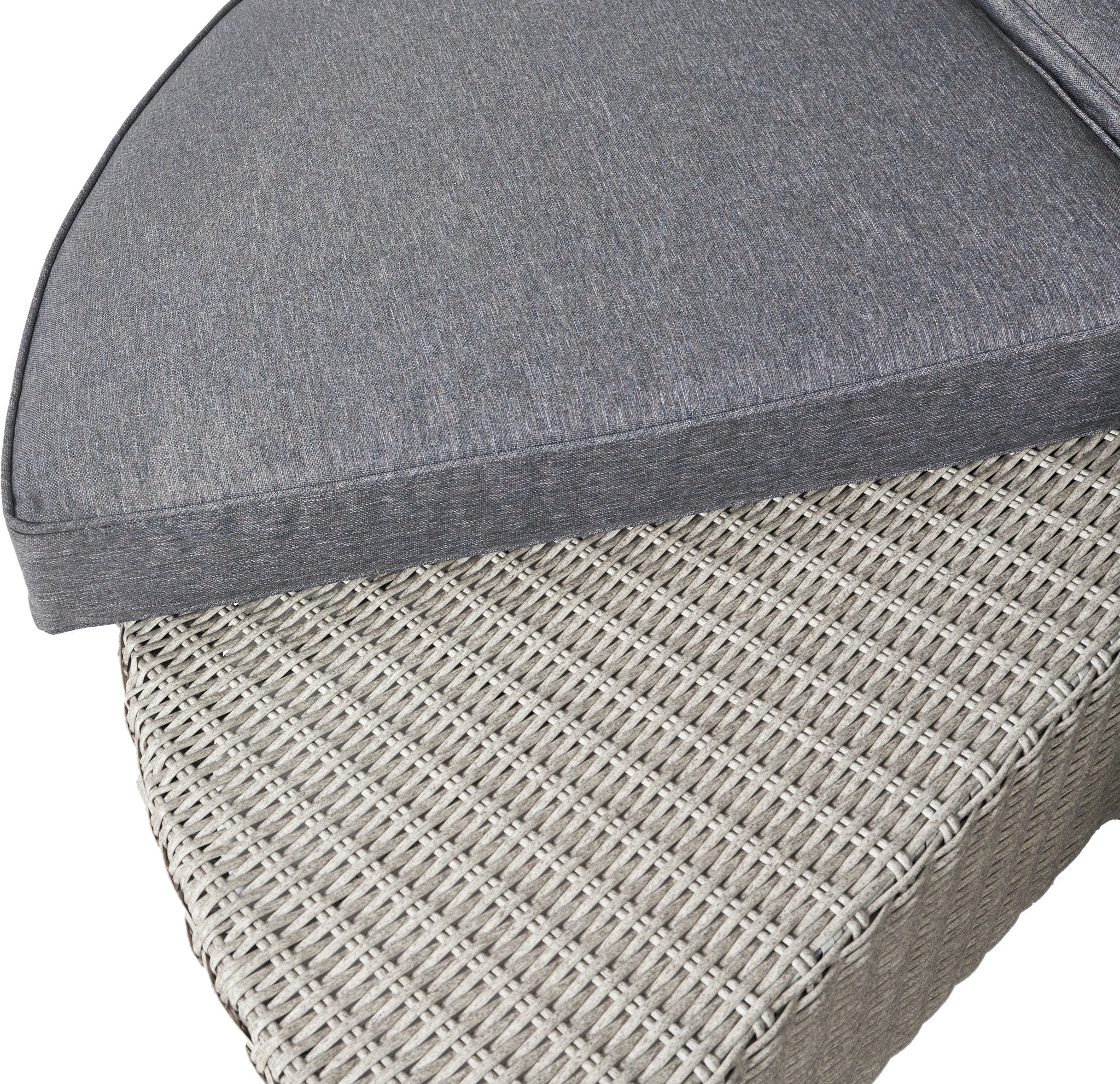 Close-up of a triangular cushion from the Pacific Lifestyle Bermuda Daybed in Stone Grey, resting on a wicker outdoor ottoman made from weatherproof material.