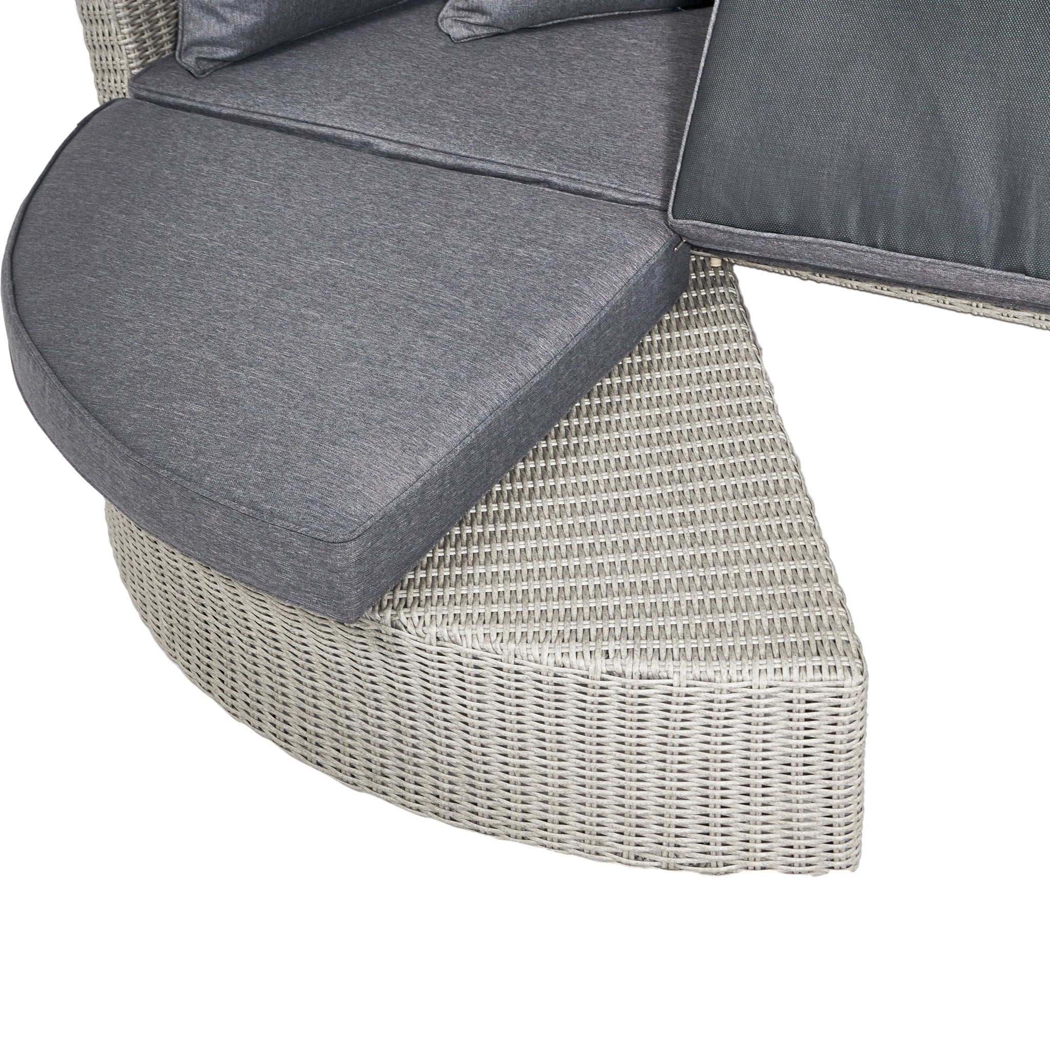 The Pacific Lifestyle Bermuda Daybed in Stone Grey features a round wicker sectional design with gray cushions, crafted from weatherproof material for lasting comfort and style.