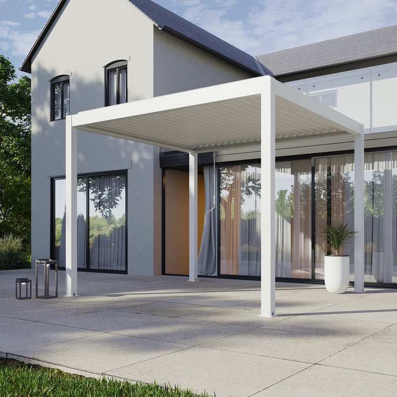 A modern house patio showcasing a PergoSTET Plus 3m x 3m square pergola in white with waterproof features, drop sides, and LED lighting, complemented by glass doors and a potted plant amidst surrounding trees.