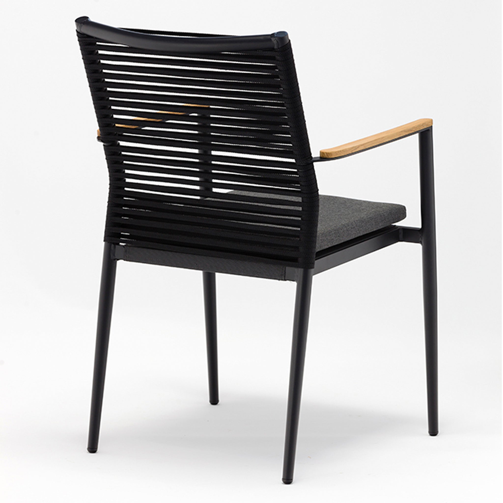 Modern Portland 4 Seat Round Dining Set with a charcoal finish, featuring a black chair with a horizontal slatted backrest, wooden armrests resembling flat rope weaved armchairs, and a grey cushioned seat against a white background.