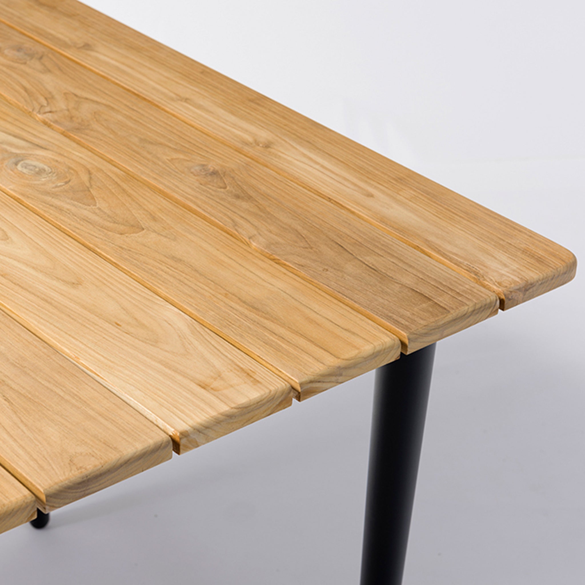 Close-up of the Kalama 8 Seat Rectangular Dining Set with a teak table in an olive green finish and black metal legs, showcasing detailed wood grain patterns. This elegant dining set is perfect for any space, combining durability and style effortlessly.