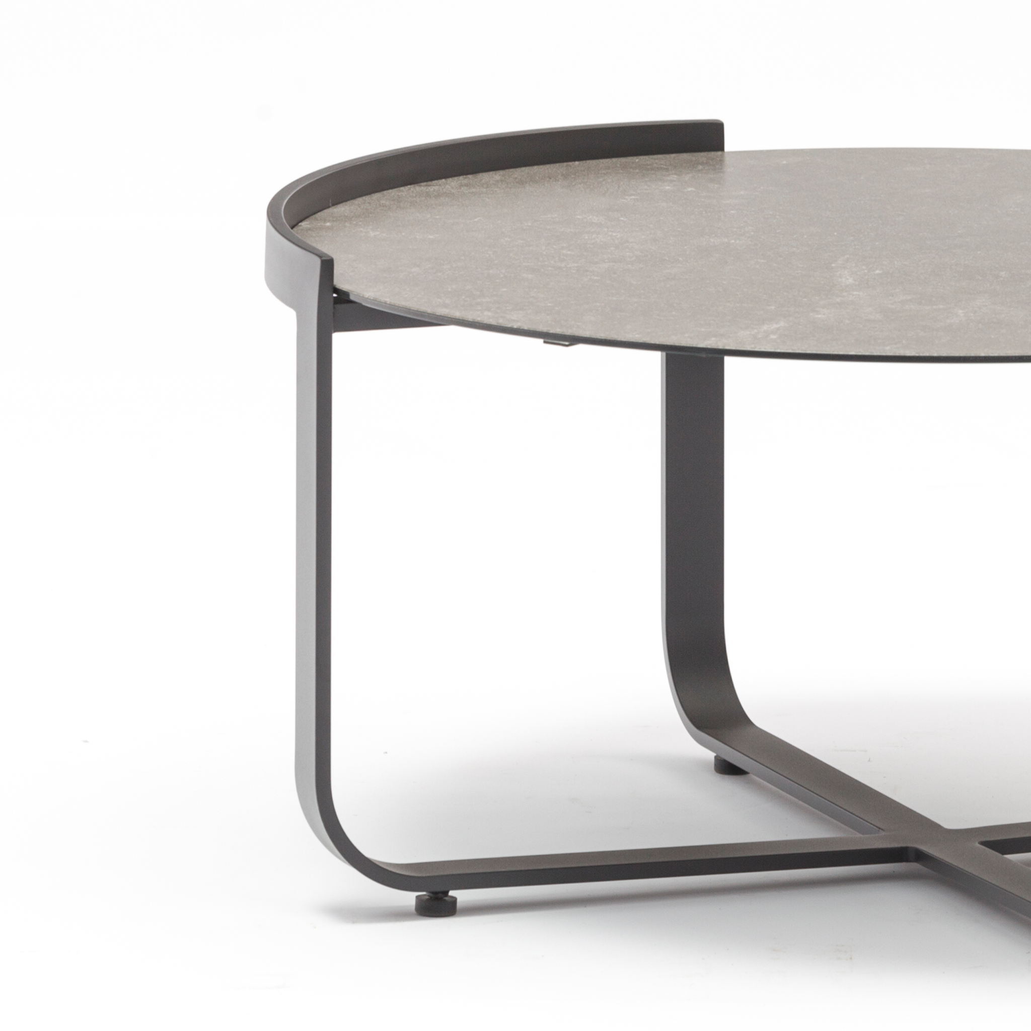 The Bloom Coffee Table 80cm with Ceramic Top in Charcoal showcases a sleek round design with a black metal frame and a ceramic glass top, highlighted by a partially raised edge on one side. Perfect as outdoor furniture, this piece effortlessly combines style and functionality.