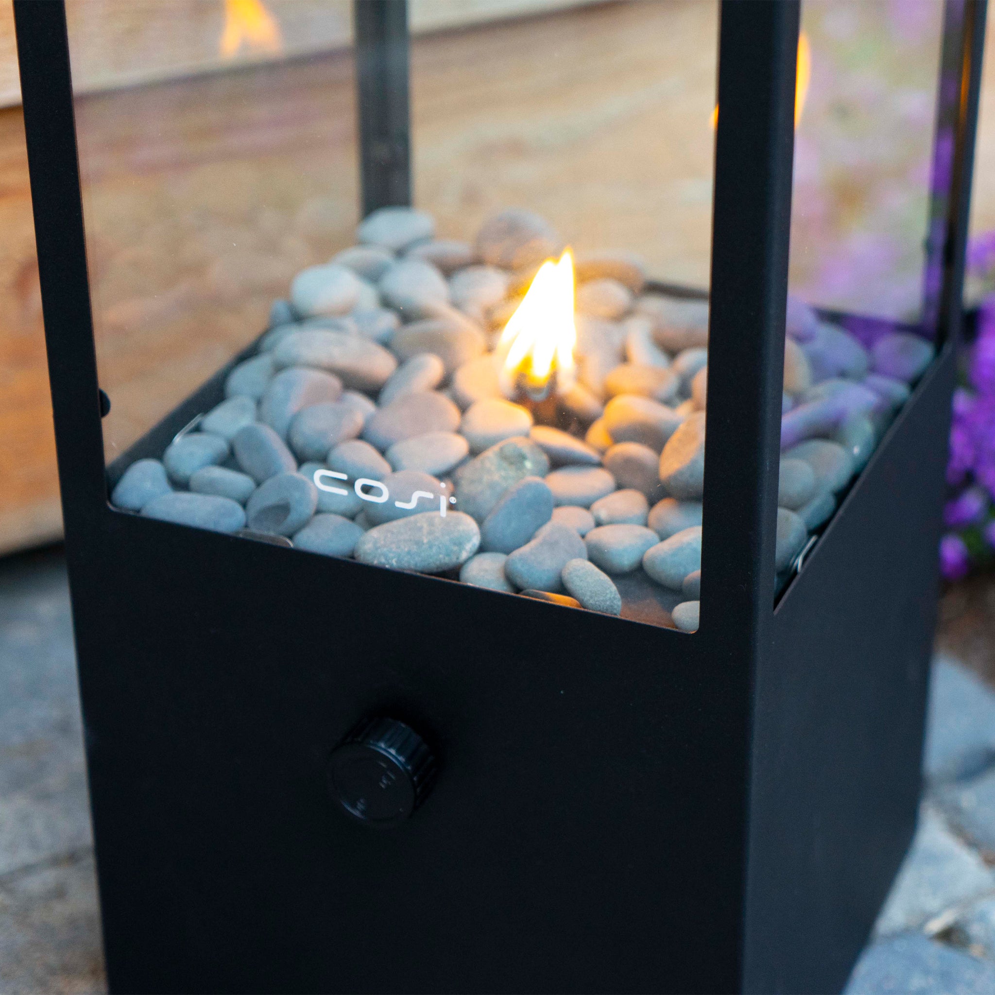 The Cosi - Cosidome High Black Fire Lantern is a sleek black tabletop fireplace with a minimalistic design, featuring pebbles and a small flame.
