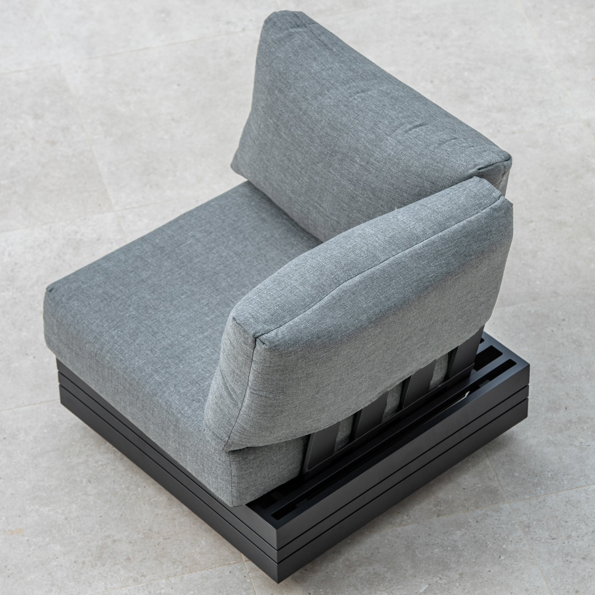 Gray sofa chair with cushions on a black slatted base, photographed from an overhead angle on a beige tiled floor. This piece can be seamlessly integrated into your existing Panama Corner Unit/Footstool in Washed Grey for a complete look.