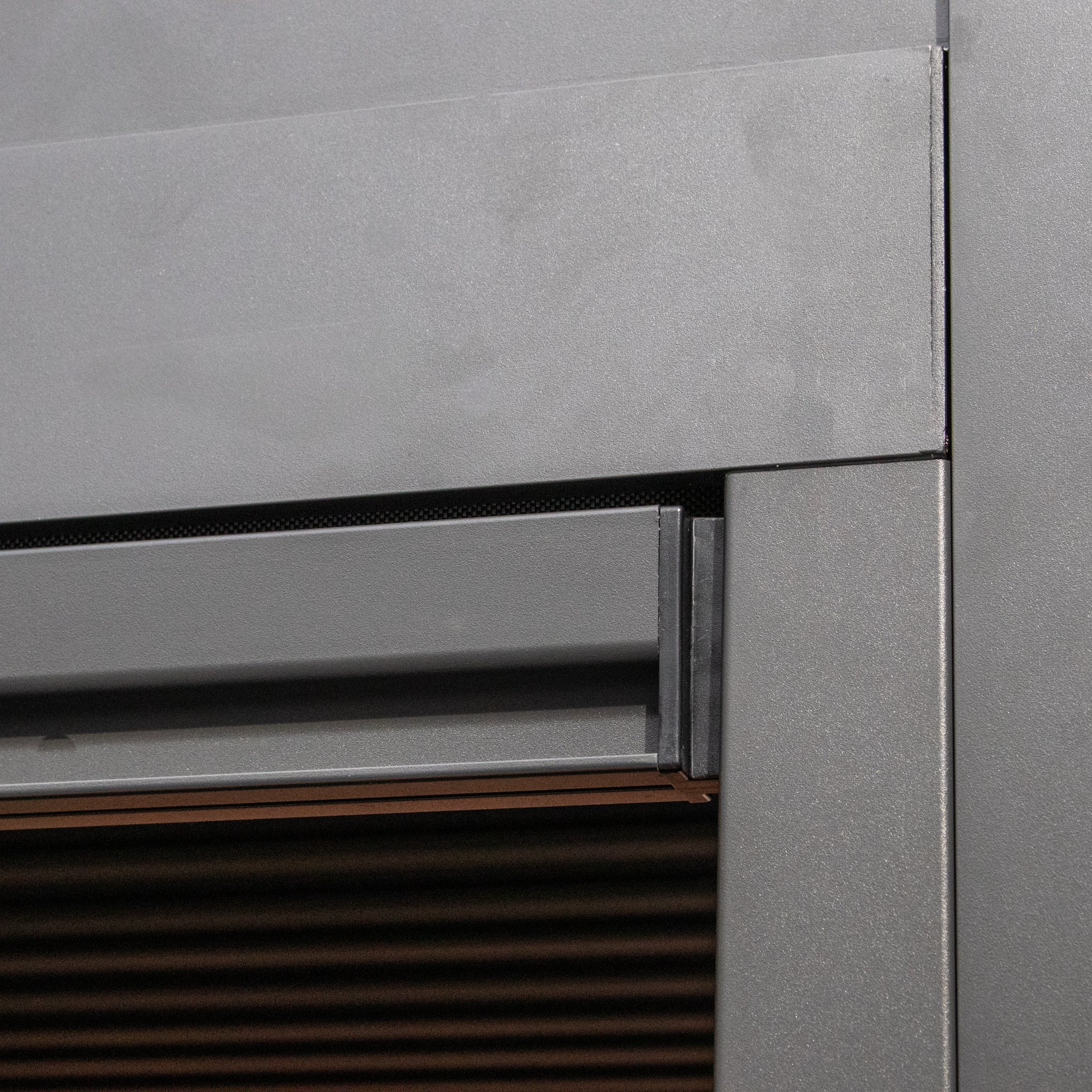 Close-up of a PergoSTET Plus 3m x 3m Square Pergola with 3 Drop Sides and LED Lighting in Grey, showcasing its modern design with sleek louvred roof, intersecting metal panels, and elegant horizontal lines.