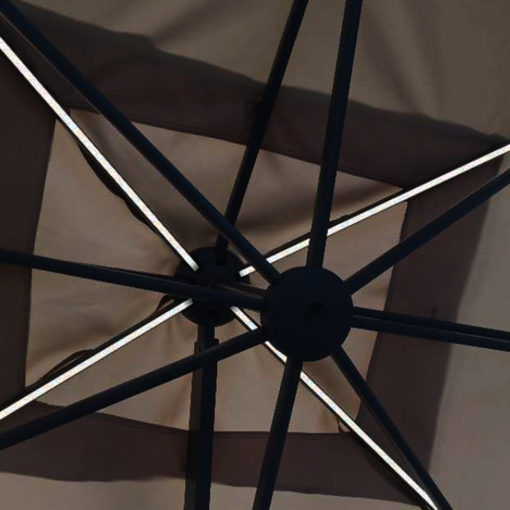 Close-up view of the underside of the Ares 3.5m Round Cantilever Parasol with Solar powered LED Lights in Charcoal, showcasing its spokes and fabric canopy, illuminated by the integrated solar-powered LED lights.