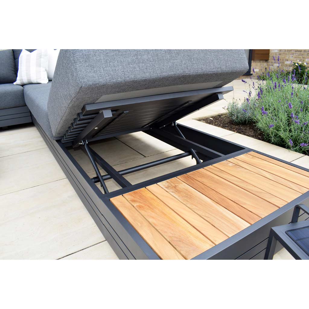 Outdoor lounge chair with an adjustable backrest, featuring a contemporary aluminium frame and a Panama Teak Side Table next to a garden with lavender plants.