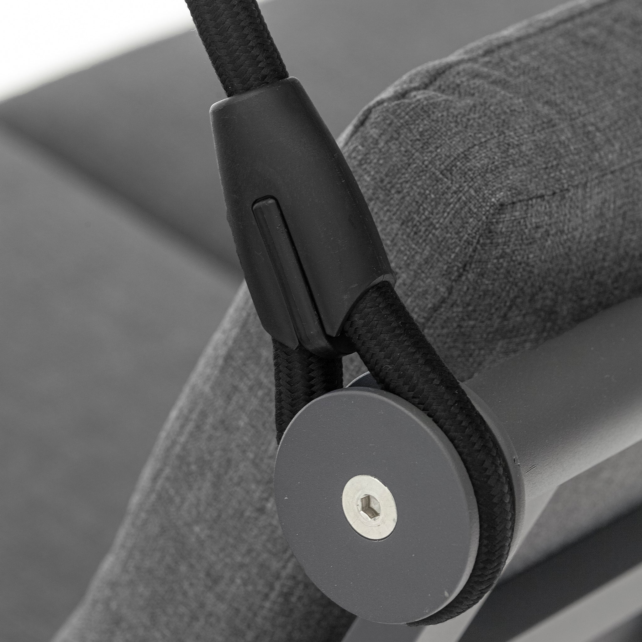 Close-up of the Lima Aluminium Swing Seat in Washed Grey, showcasing a black rope secured with a black plastic clip to the powder-coated aluminium frame, adjacent to a grey cushion.