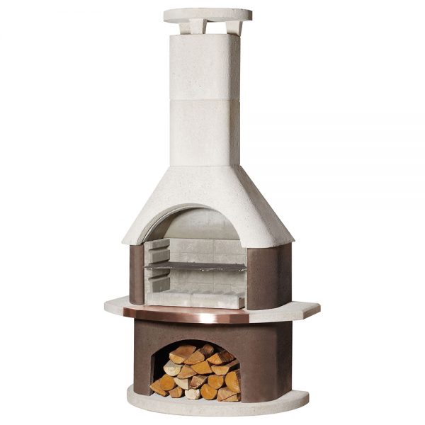 Outdoor stone fireplace with a tall chimney, metal accents, and a storage area filled with firewood at the base, exuding rustic elegance. This Buschbeck San Remo Masonry Barbecue features double-skinned construction for added durability.