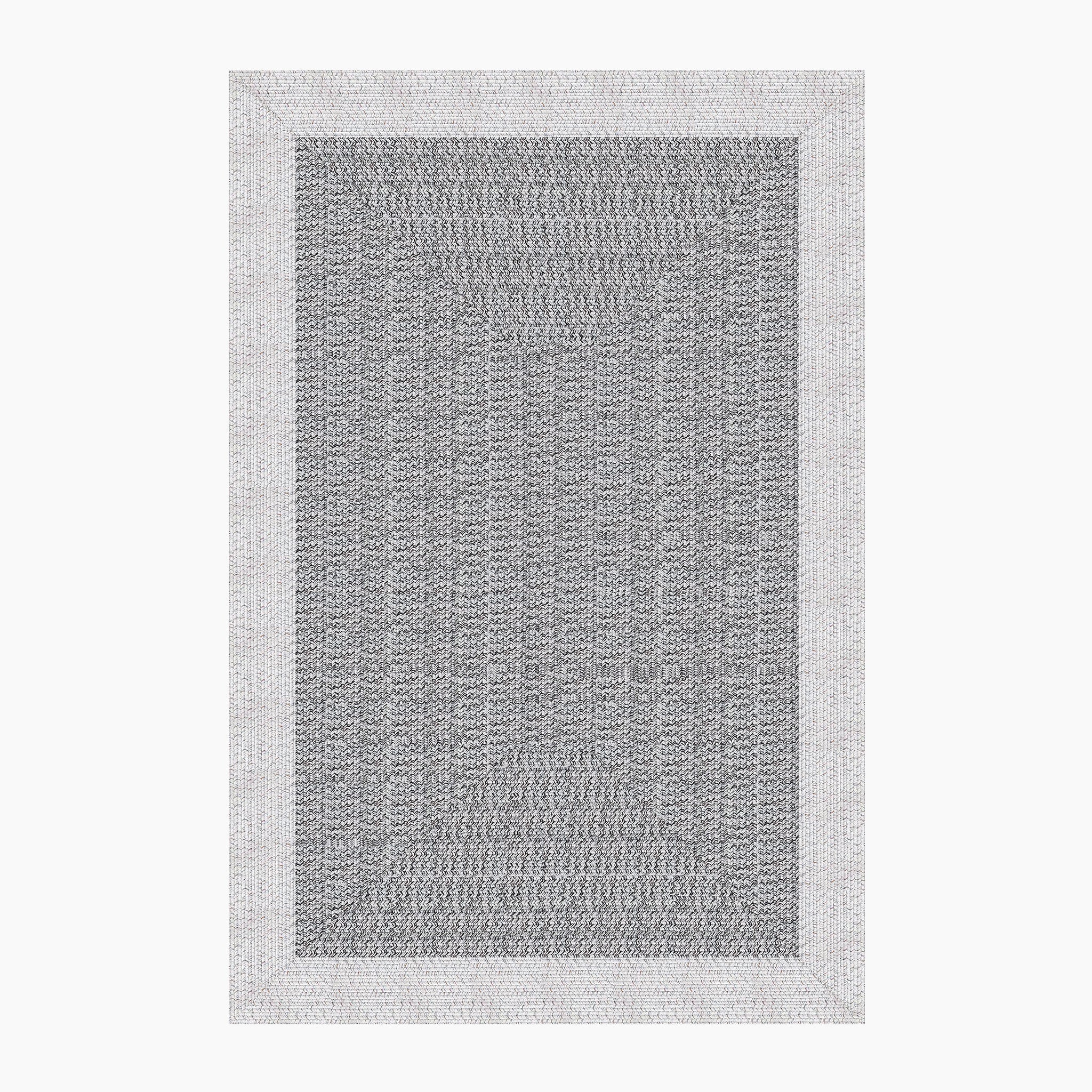 The Hades 290cm x 190cm Weatherproof Indoor and Outdoor Rug in Cobble Grey is a rectangular woven area rug featuring a dark Cobble Grey center and a light gray border, designed to be UV resistant.